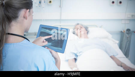 Zusammengesetztes Bild des Arztes betrachten Xray auf tablet Stockfoto