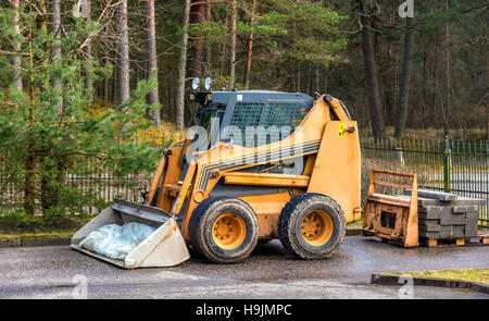 Bobcat oder Skid Loader geparkt im Wald Stockfoto