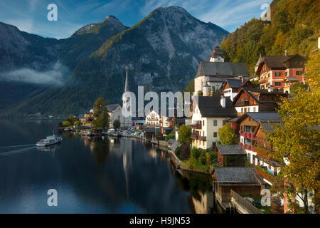 Fähre und Sonnenaufgang über Stadt Hallstatt und Traun, Saltzkammergut, Österreich Stockfoto