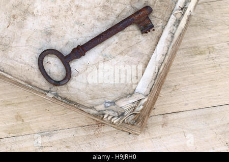 Detail der alten rostigen Schlüssel auf das zerfledderte Buch Stockfoto