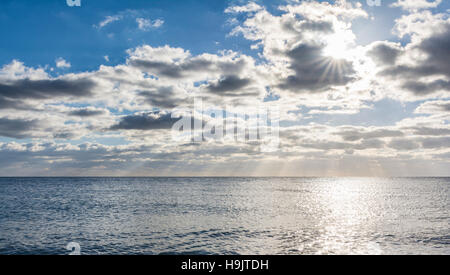 Sonne hinter Wolken über dem Meer. Stockfoto