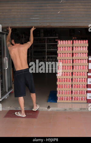 PHUKET, THAILAND - 25. November 2014: Stapel von Kasten Coca-Cola Erfrischungsgetränke-Flaschen in Warenhouse. Alkohol in Gläser stehen in den Regalen entlang Wand. Mann-op Stockfoto