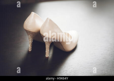 Weiße Braut Hochzeitsschuhe auf Holztisch. Ehe-Konzept Stockfoto