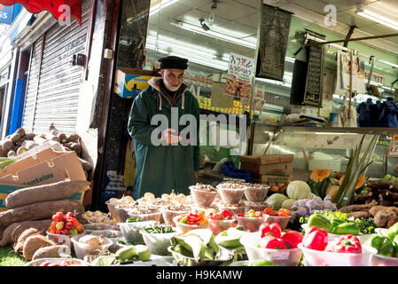 Shop-Betreiber einer kleinen Früchten und Gemüse und halal Metzgerei in Ridley Straße Markt im Herzen von Dalston, Ostlondon. Stockfoto