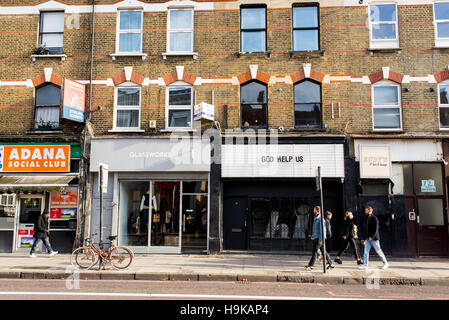 Trendige junge Menschen wandern in Stoke Newington Road vor coole Indie-Geschäften. In Dalston, East London gedreht. Stockfoto