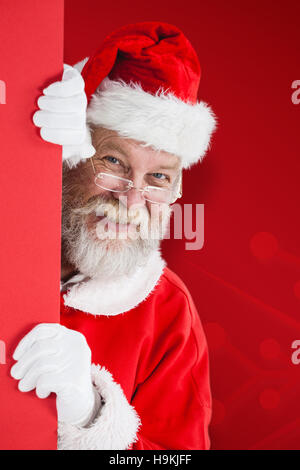 Zusammengesetztes Bild des Weihnachtsmannes spähen aus roten board Stockfoto