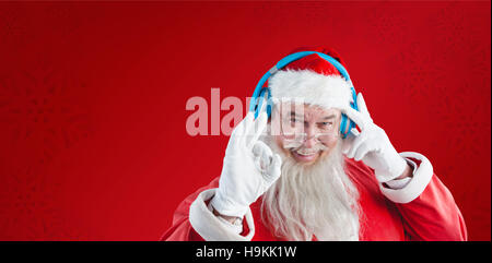 Zusammengesetztes Bild Porträt des Weihnachtsmannes Hand Ordnung Anzeichen beim Musikhören auf headph Stockfoto