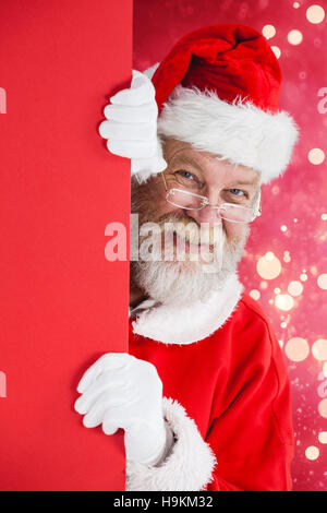 Zusammengesetztes Bild des Weihnachtsmannes spähen aus roten board Stockfoto