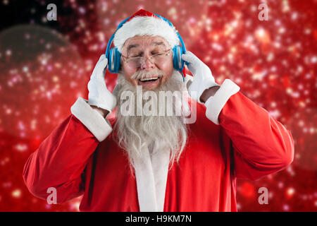 Zusammengesetztes Bild von Santa Claus Musik über Kopfhörer hören Stockfoto