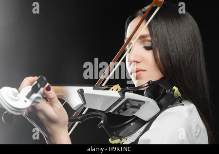 Frau auf einem schwarzen Hintergrund mit dem Geigenspiel Stockfoto