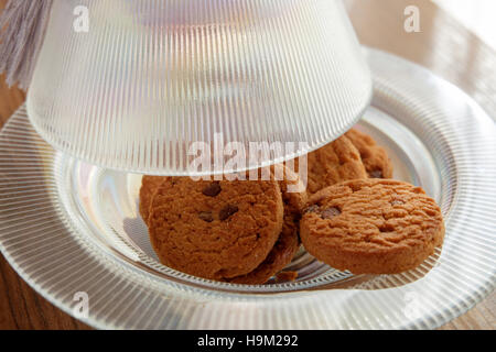 Chocolate Chip Cookies auf einer Glasplatte mit Deckel Stockfoto