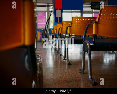 leere gelbe Stühle in einem Busstation Stockfoto