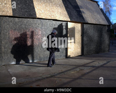 tief stehender Sonne auf städtischen einzelne Person zu Fuß alleine Schatten Ampel Stockfoto