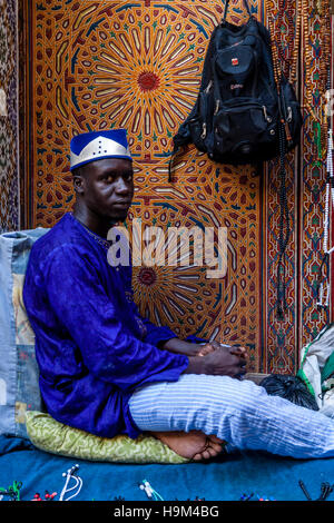 Eine senegalesische Mann verkaufen Schmuck und Souvenirs In der Medina, Fes el Bali, Fes, Marokko Stockfoto