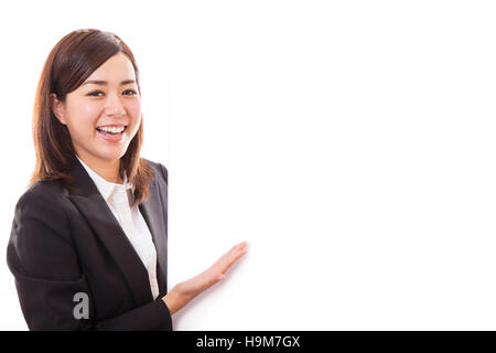 Lächelnde junge Frau zeigt leer Board während Stockfoto