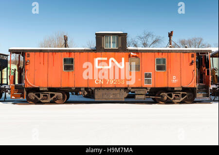 Old orange Farbe Canadian National Railway, CN Caboose parkte im Winter auf dem Hof Stockfoto