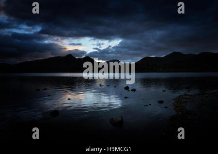 Tag wird zur Nacht an den ruhigen Ufern des Derwentwater im Lake District.  (Catbells und Maiden Moor in der Silhouette) Stockfoto