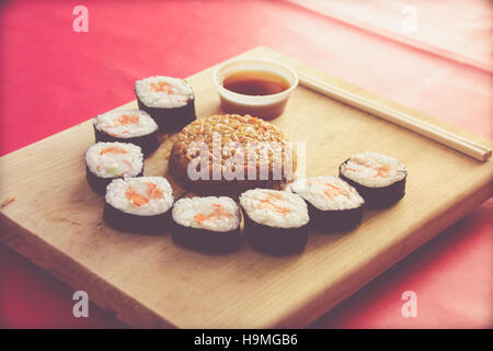 Phtograph einige Sushi Rollen Scheiben und gebratenen Reis auf einem Holztisch Stockfoto