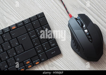 Draufsicht der schwarzen Computer-Maus und Tastatur mit englischen und russischen Buchstaben Stockfoto