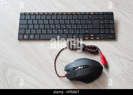 Draufsicht der schwarzen Computer-Maus und Tastatur mit englischen und russischen Buchstaben Stockfoto