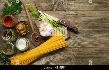 Pasta mit Gewürzen und Zutaten auf alten Holztisch Stockfoto