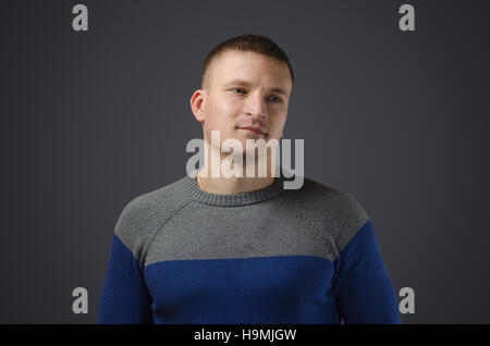 Porträt eines jungen schwulen Männern, lächelt. Emotionale Fotos im Studio auf einem schwarzen Hintergrund Stockfoto