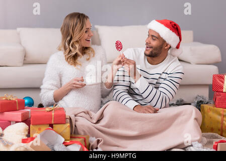 Schöne fürsorglichen Mann mit seiner Frau einen Lutscher Stockfoto