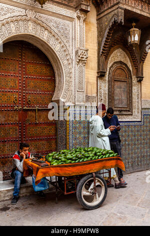 Ein junger Mann verkauft Avocados von A Cart In The Street, Fes el Bali, Fes, Marokko Stockfoto