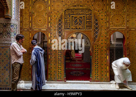 Ein Tourist und A Tour Guide außerhalb der Zaouia Moulay Idriss 2 Moschee und Schrein, Fes el Bali, Fes, Marokko Stockfoto