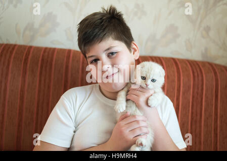 Junge Teenager halten Kätzchen im Arm Stockfoto