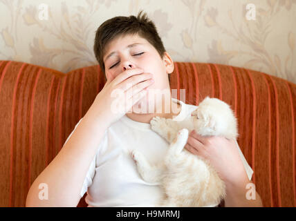 Der junge ist allergisch gegen Katzen Stockfoto