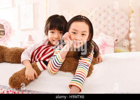 Niedliche kleine Mädchen spielen auf dem Bett Stockfoto