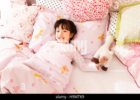 Niedliche kleine Mädchen im Bett Stockfoto