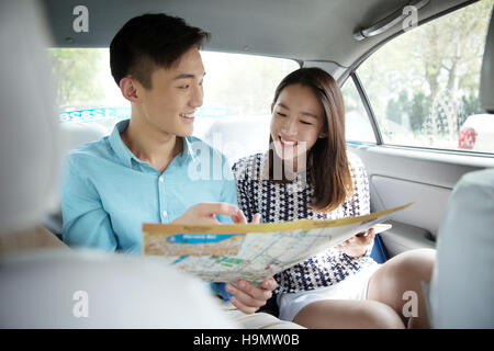 Junge Liebhaber im Auto um die Karte zu sehen Stockfoto