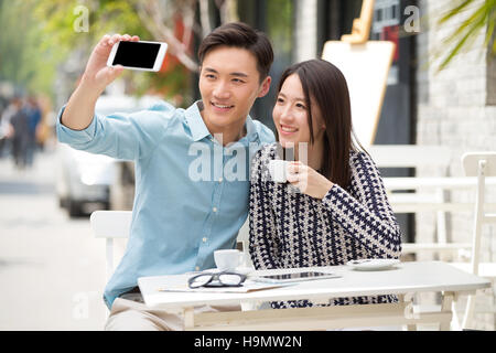 Junge Liebhaber mit Mobile Telefon selbst Timer Stockfoto