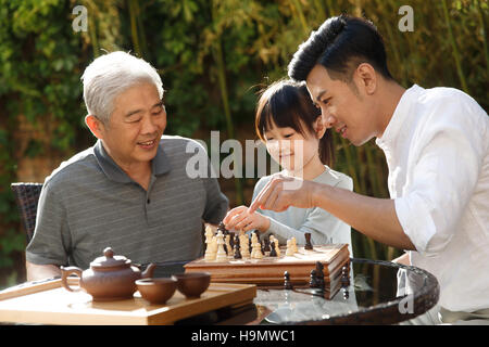 Drei Generationen auf dem Hof spielen Schach Stockfoto