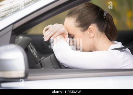 Junge Frau, die ihr telefonieren Autofahren Stockfoto