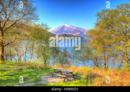 Picknick-Sitzbank anzeigen Loch Leven Schottland Schottisches Hochland um Schnee gekrönt Berg in bunte HDR Stockfoto