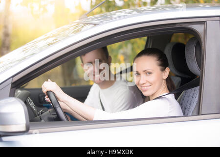 Junge Autofahrerin, einen Mann sitzt in der Nähe im Auto Stockfoto