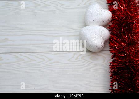 Red Garland mit zwei weißen Herzen auf hölzernen Hintergrund Stockfoto