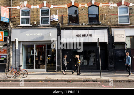 Trendige junge Menschen wandern in Stoke Newington Road vor coole Indie-Geschäften. In Dalston, East London gedreht. Stockfoto