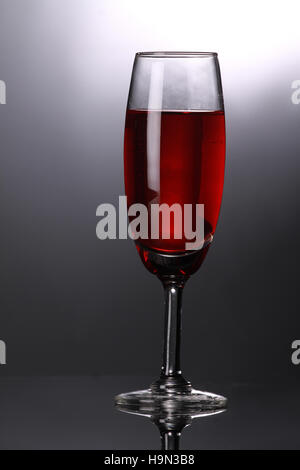 Luxus rot Wein im Sektglas auf grauem Hintergrund Stockfoto