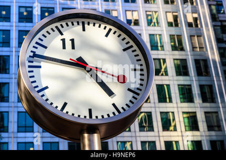 Öffentliche Uhr in Canary Wharf in London gegen Bürogebäude Stockfoto