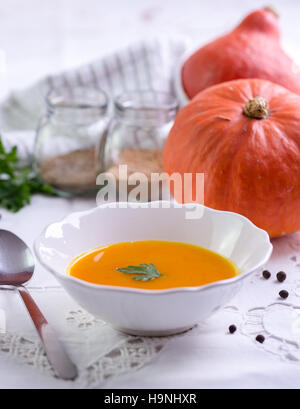 Herbstliche Kürbissuppe orange auf weißem Tischtuch. Stockfoto