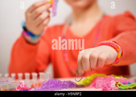 Mädchen von farbigen Gummiband Armband weben Stockfoto