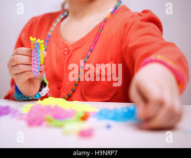 Mädchen von farbigen Gummiband Armband weben Stockfoto