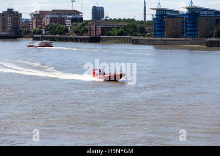 Eine Fähre und mit dem Schnellboot entlang der Themse in der Nähe von Canary Wharf Pier, London reisen.  14. Juli 2014. Stockfoto