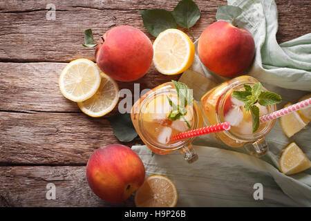 Pfirsich Limonade mit Minze und Eis hautnah in einem Glas auf dem Tisch. Horizontale Ansicht von oben Stockfoto