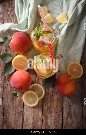 Pfirsich Limonade mit Minze und Eis hautnah in einem Glas auf dem Tisch. Vertikale Ansicht von oben Stockfoto