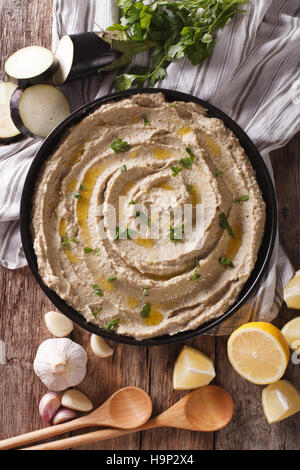 Arabische Lebensmittel Baba Ghanoush close-up auf dem Teller und Zutaten auf den Tisch. vertikale Ansicht von oben Stockfoto